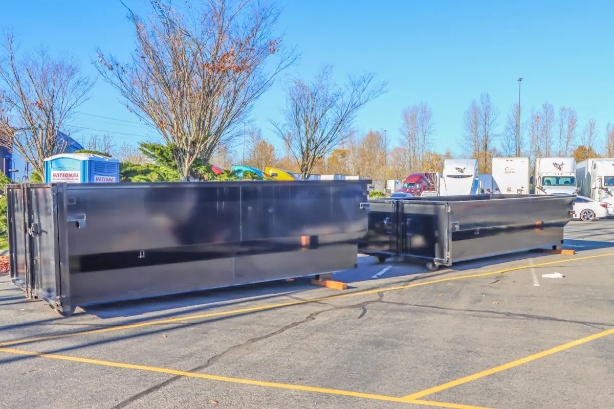 Professional dumpster rental service with roll-off container on residential driveway in River Rouge